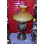 A vintage brass based oil lamp with orange glass shade. Shipping unavailable.