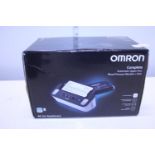 A boxed Omron blood pressure monitor