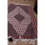 A large hand woven Persian rug approximately 185cm x 110cm