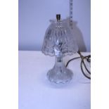A glass hurricane style electric lamp