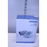 A boxed Omron blood pressure monitor