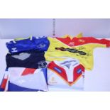 A selection of assorted sports shirts and flags, including a kids signed shirt.