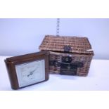 A small wicker basket and a vintage oak cased barometer