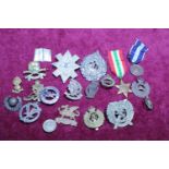 A selection of assorted cap badges and medals including a WWII Greek 1940-41 medal