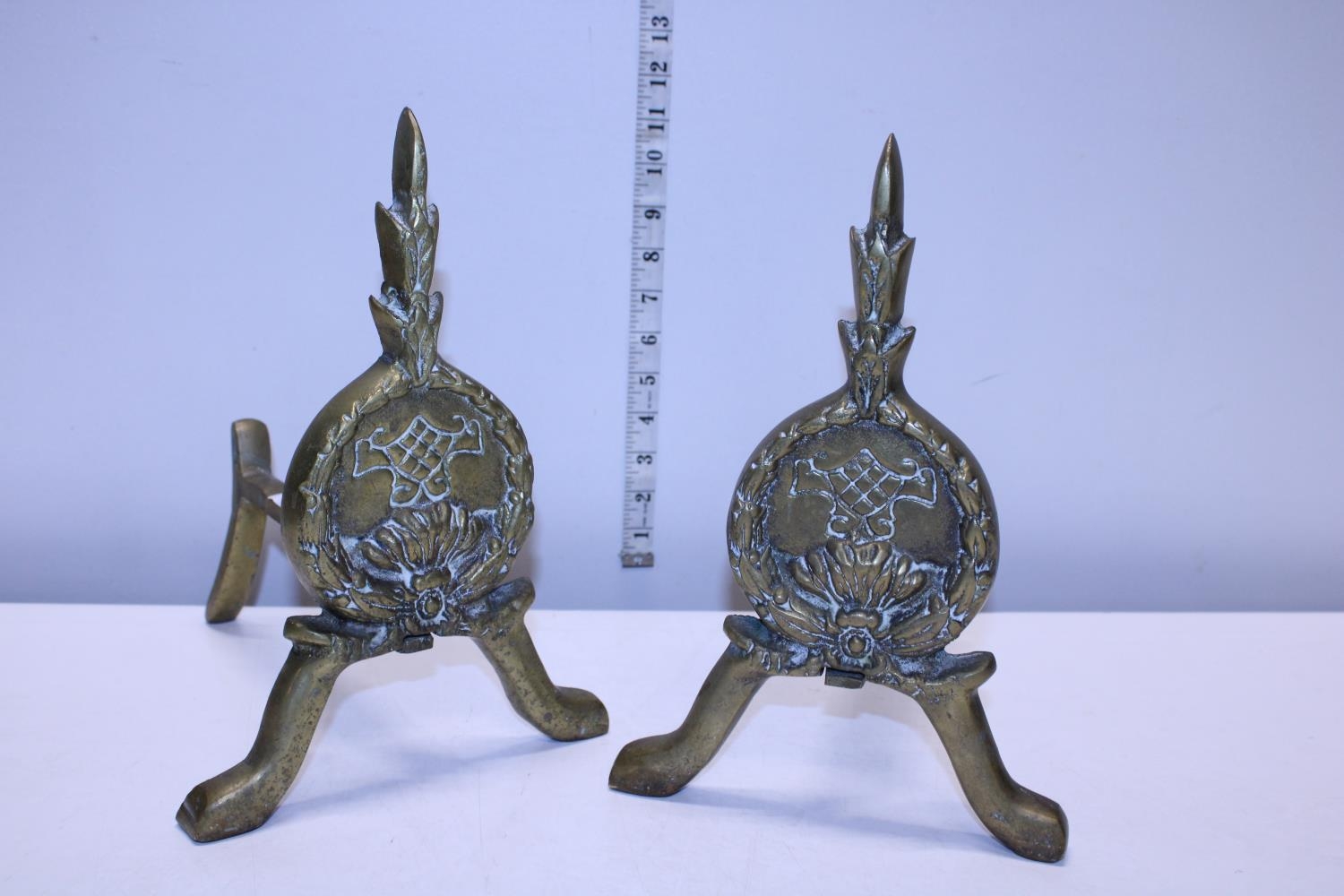 A pair of antique heavy brass fire dogs
