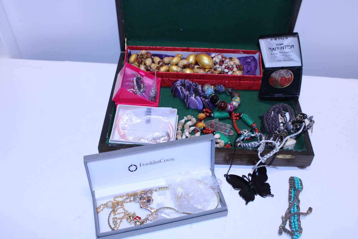 A wooden box and contents of costume jewellery