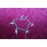 A silver bracelet with white metal charms