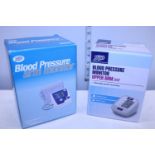 Two boxed blood pressure monitors