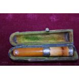 An antique cased amber and silver mount cheroot holder
