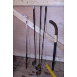 A small selection of vintage golf clubs and a hockey stick