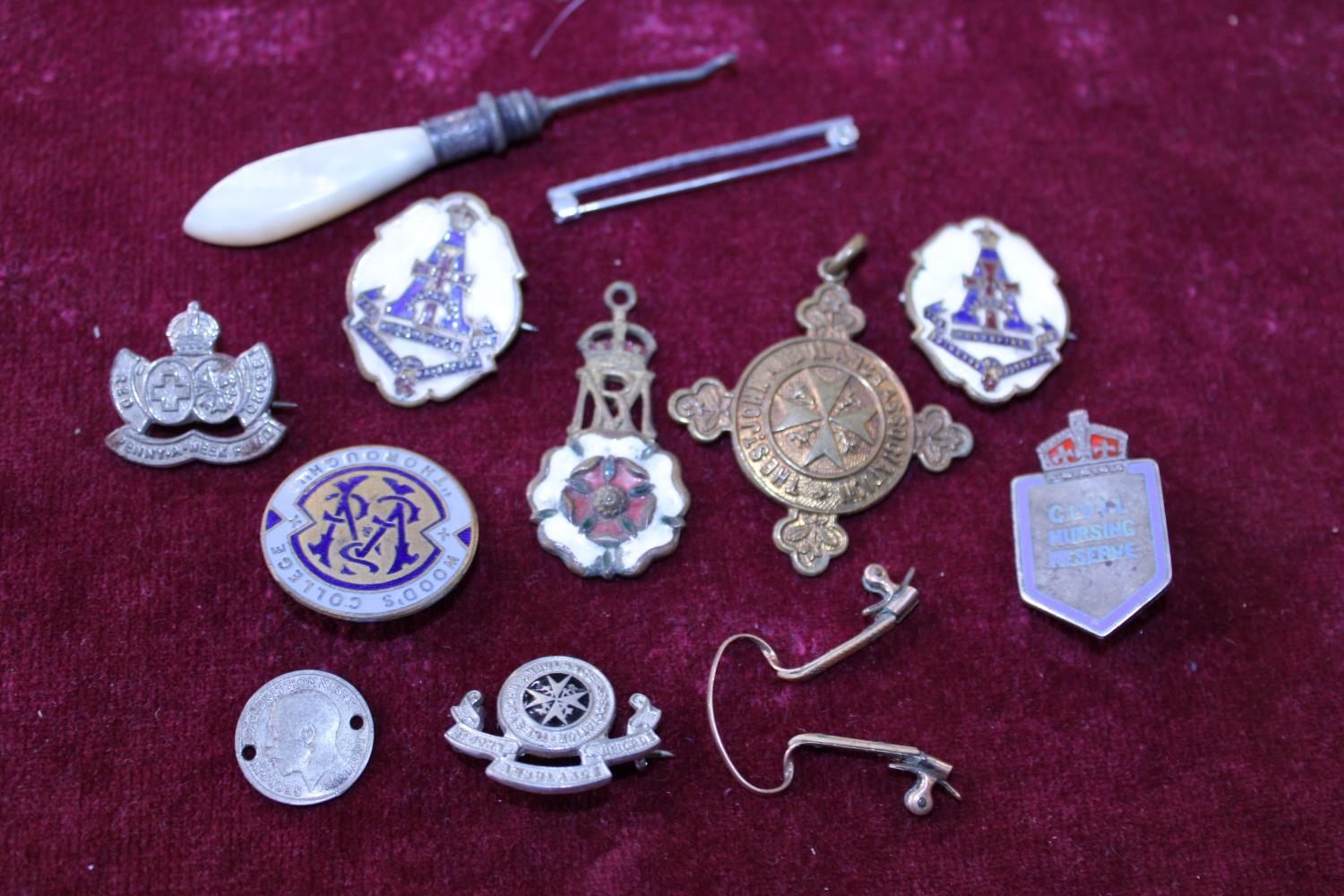 A selection of assorted enamel badges and other items