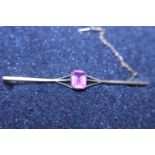 A antique 9ct gold bar brooch with safety chain and pink stone