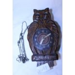 A vintage wooden and tin plate owl clock