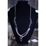 A silver and purple stone necklace