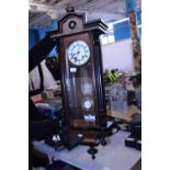 A cased Vienna wall clock in working condition with key and pendulum, shipping unavailable