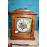 A wooden cased mantle clock with key in working order