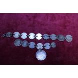 A selection of antique silver coins on chain