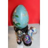 A large Cloisonne egg on stand and selection of smaller cloisonne eggs