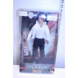 A boxed Michael Jackson figure (box damaged)