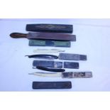 A selection of vintage cut throat razors and a cut throat razor strop