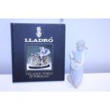 A Nao figure and a Lladro collectors book