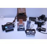 A selection of vintage cameras including a Polaroid SX-70 land camera , Olympus Pen EE and a Canon