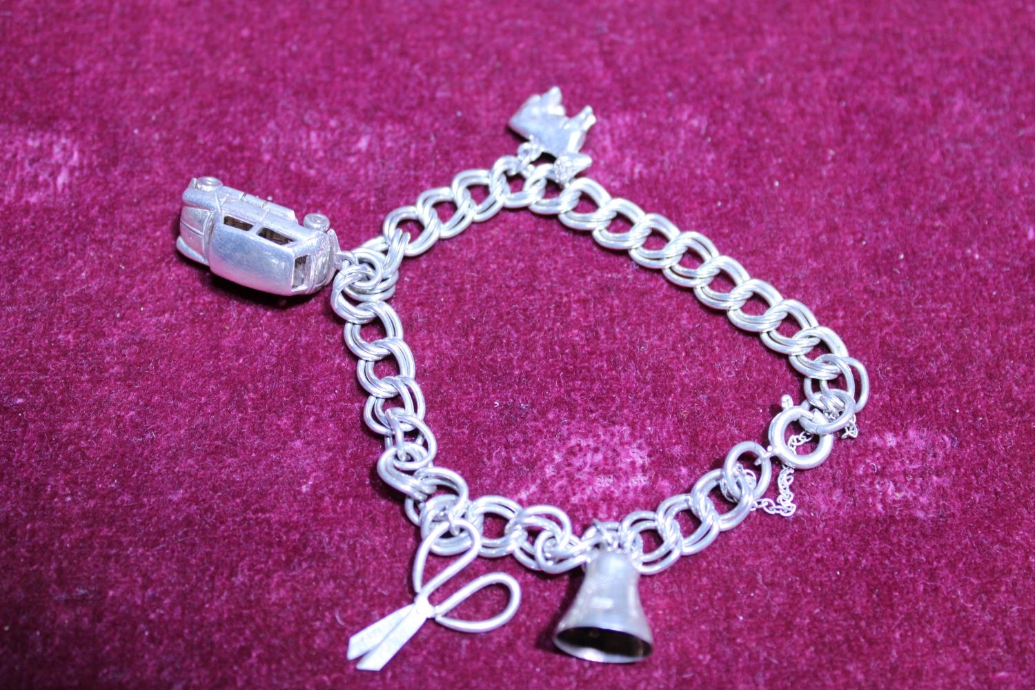 A white metal bracelet and a selection of white metal charms