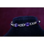 A hallmarked 9ct gold bracelet with Amethyst and Seed pearl decoration and safety chain gross weight