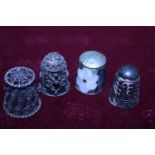 Four assorted silver thimbles