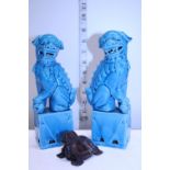 A pair of blue ceramic Foo dogs and a soapstone carved Foo dog