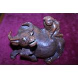A hand carved wooden sculpture of a Chinese water buffalo with a figure on the back 21cm x 16cm