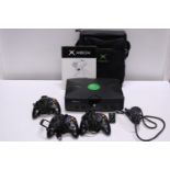 A Xbox with three controllers, carry case (no power lead), untested