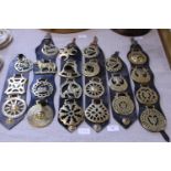 A selection of antique horse brasses on leather straps