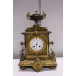 A heavy gilt brass mantle clock with enamel face, with key and pendulum. Shipping unavailable