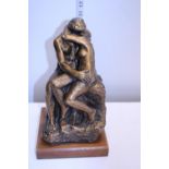 A heavy erotic sculpture on a wooden base