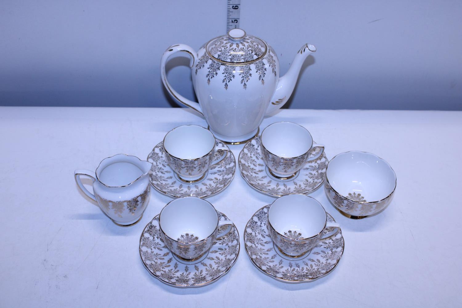 A Bone China tea service with 22ct gold decoration, chip to milk jug