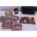 A selection of assorted new tinned jigsaws and with selection of playworn die-cast