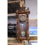 A antique walnut cased Vienna wall clock with pendulum and key slight damage to freeze, shipping