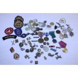 Tin of assorted enamel badges patches and medals including military