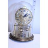 A vintage Kundo brass mantle clock under glass dome