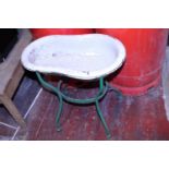 An antique child's enamel bath on a wrought iron stand. postage unavailable