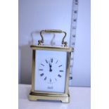 A brass cased cartridge clock by Churchill in working order