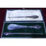 A antique cased hallmarked silver handled button hook & shoe horn set. And one other silver