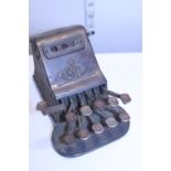A antique cast metal calculator called 'The Adder'.