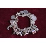 A 925 silver charm bracelet & charms 73.08 grams