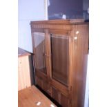 A glazed Ercol cabinet with under cupboard. Shipping unavailable