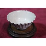 A Chinese 18th Century Blanc de Chine fluted porcelain bowl on wooden stand