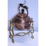 A vintage copper kettle on brass stand