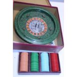 A vintage boxed roulette wheel with chips