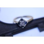 A vintage 18ct gold ring with central Diamond flanked by four Sapphires total weight 3.67g size O